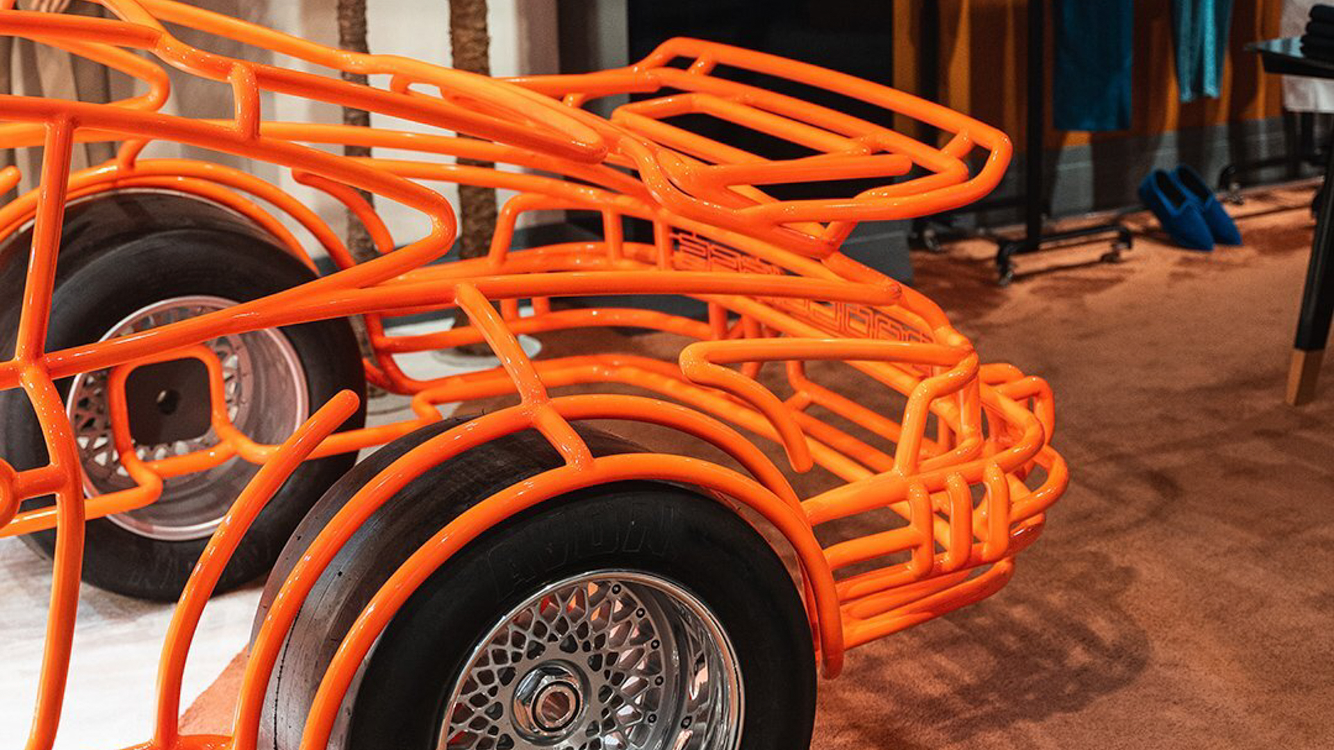 The vibrant Fluro Orange finish of the Porsche 934 steel sculpture, highlighting its unique color.