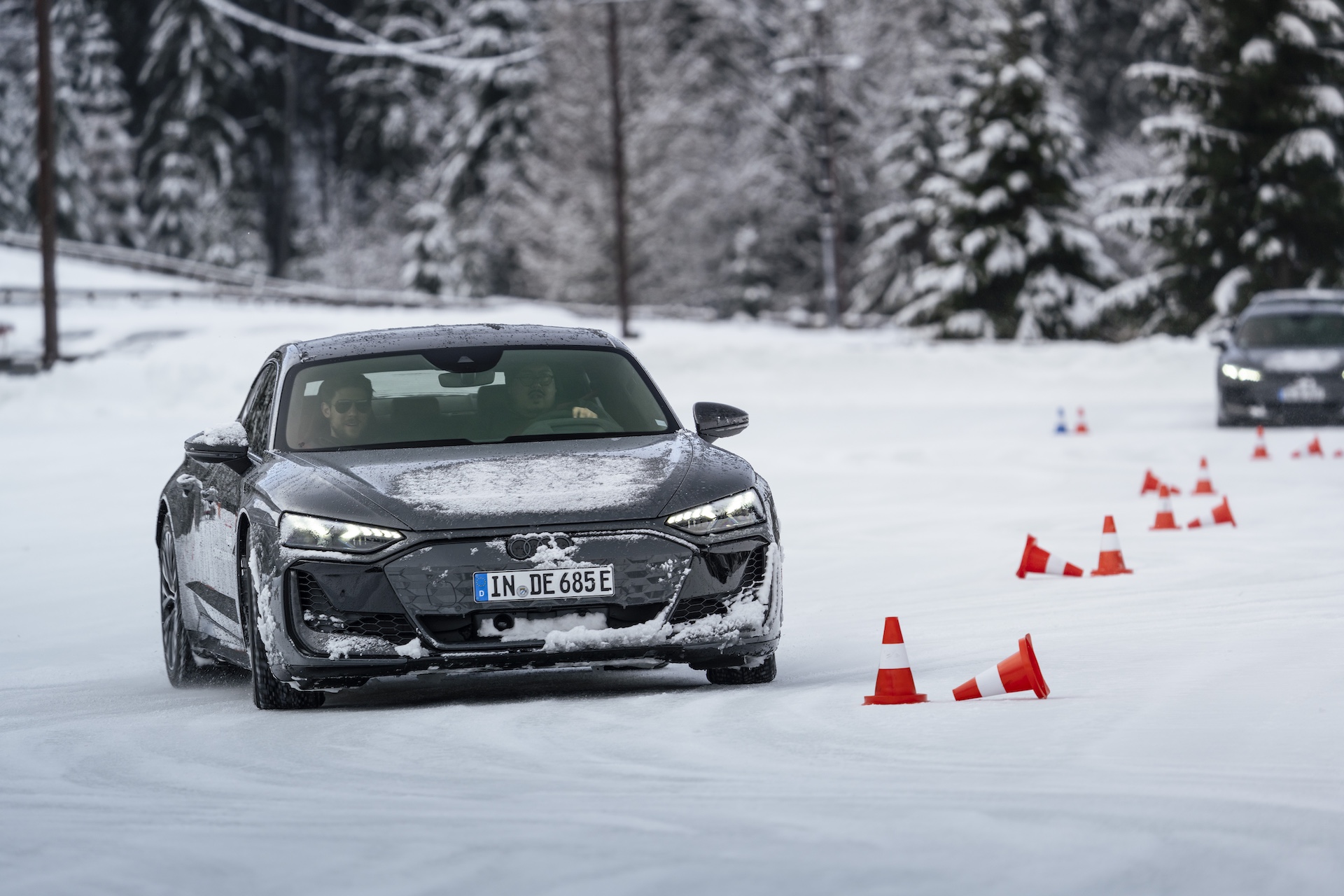 A driver practicing car control on ice, navigating a course with understeer and oversteer challenges.
